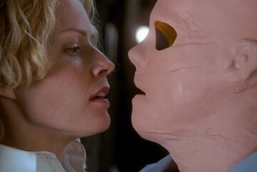 Hollow Man (2000) An Invisible Kevin Bacon, wearing a crudely made latex mask with no visible eyes stares threateningly at scared but calm Elisabeth Shue