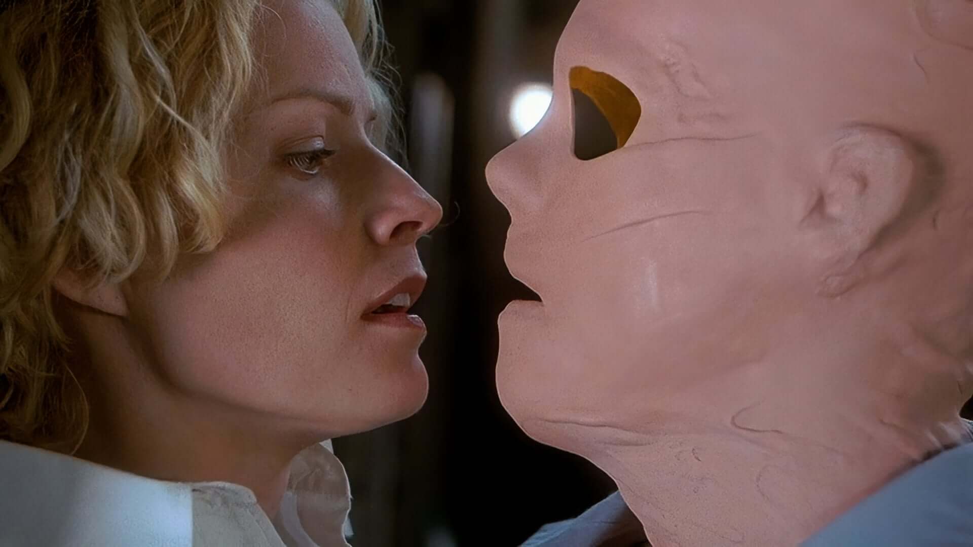 Hollow Man (2000) An Invisible Kevin Bacon, wearing a crudely made latex mask with no visible eyes stares threateningly at scared but calm Elisabeth Shue