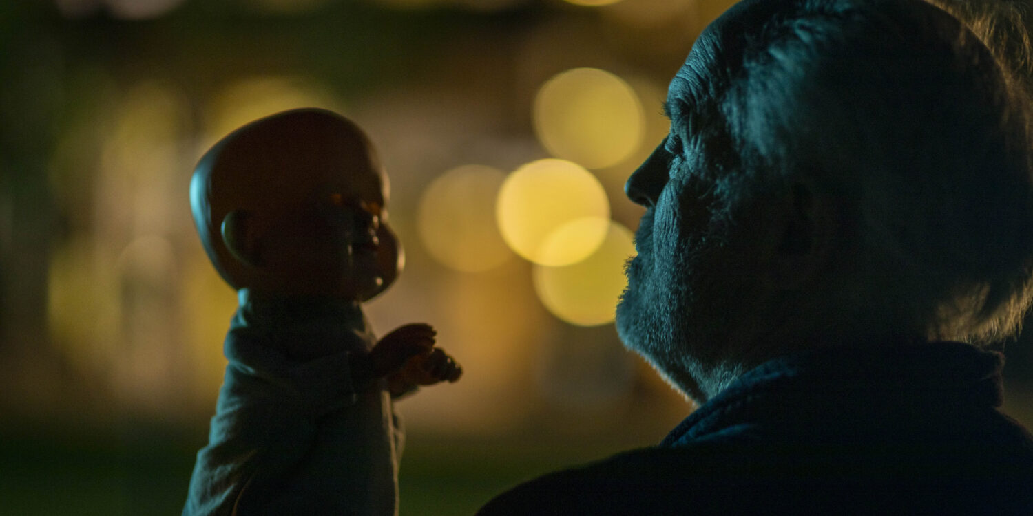 THE RULE OF JENNY PEN (2025) - John Lithgow as Dave Crealy talks with his hand Puppet Jenny Pen in the moonlight