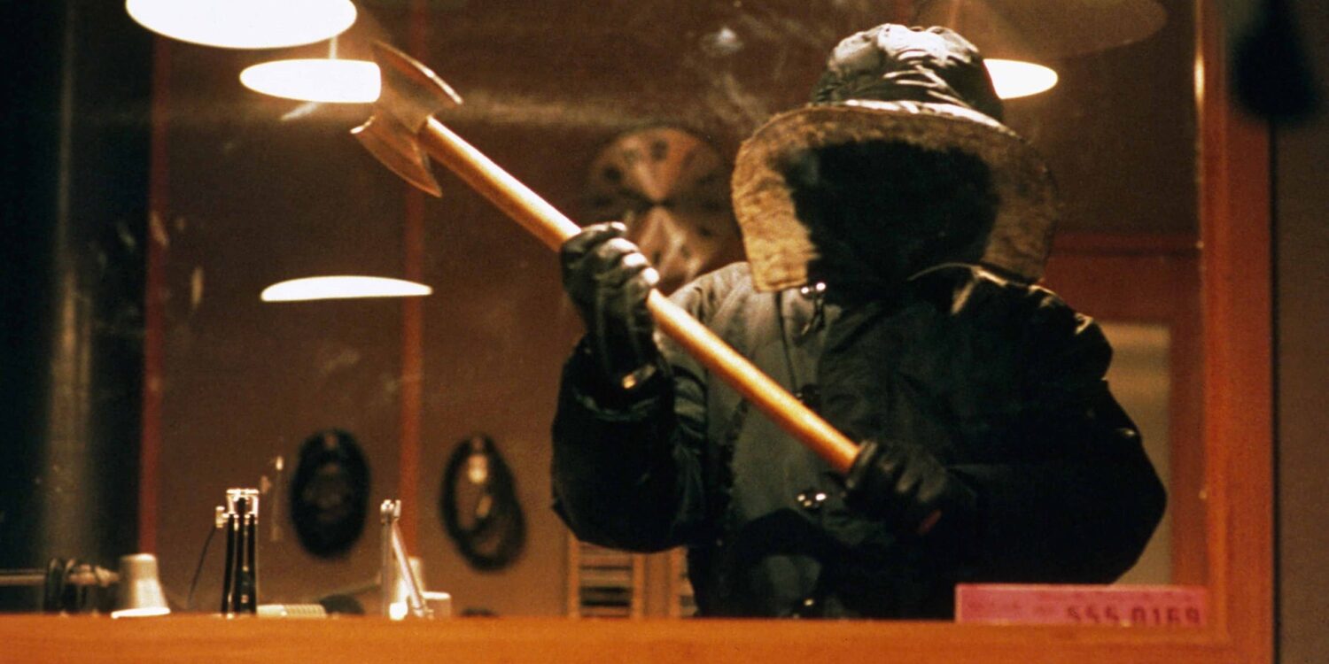 Urban Legend (1998) - The Killer Stalks in The Univerisity Radio Statio,, wearing a snow jacket that obscures their identity, wielding an axe