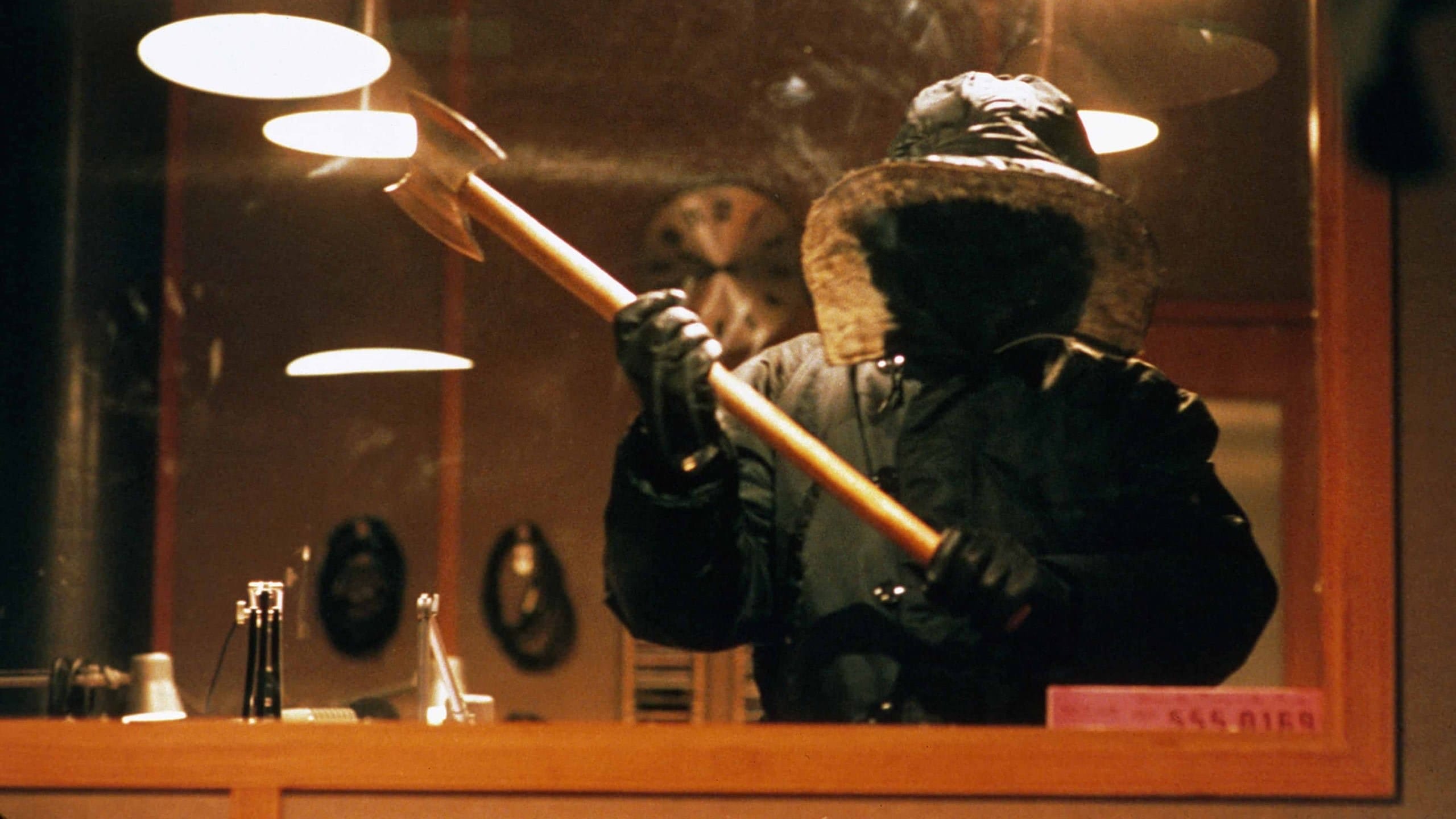 Urban Legend (1998) - The Killer Stalks in The Univerisity Radio Statio,, wearing a snow jacket that obscures their identity, wielding an axe