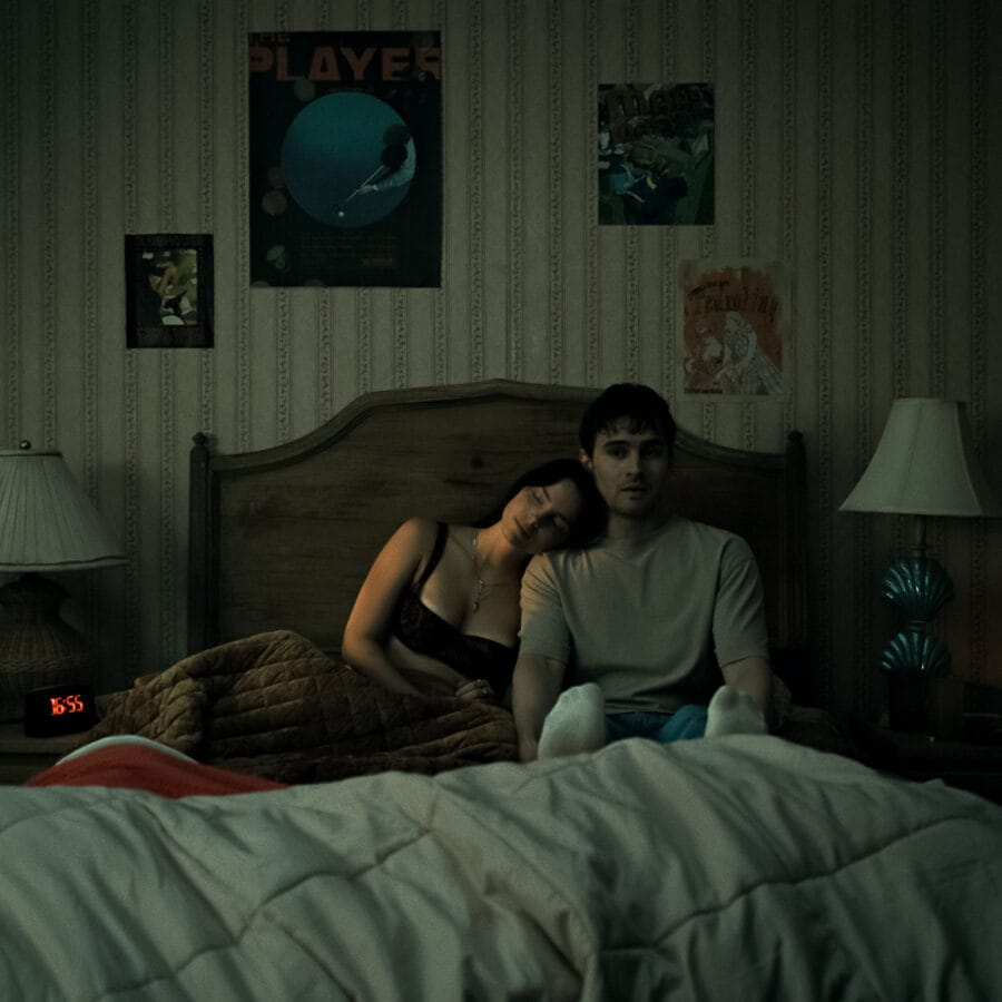Inde Navarrette stars as Nikki and Michael Johnston as Bear in OBSESSION, a Focus Features release. Nikki and Bear Sitting next to each other in Bed